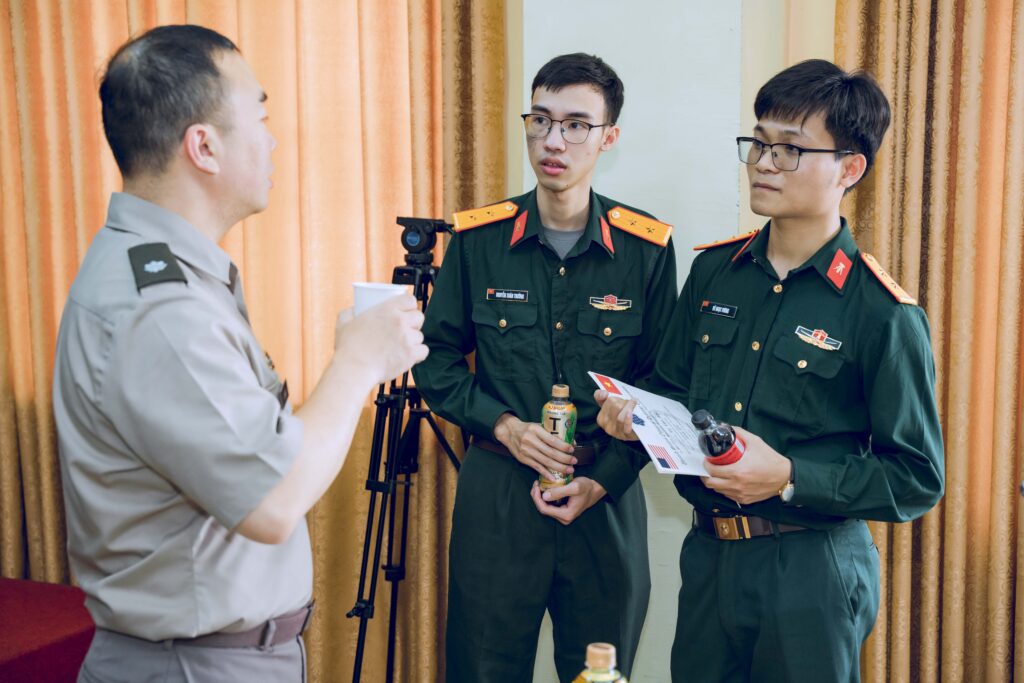 A US colonel speaking with two Vietnamese lieutenants.